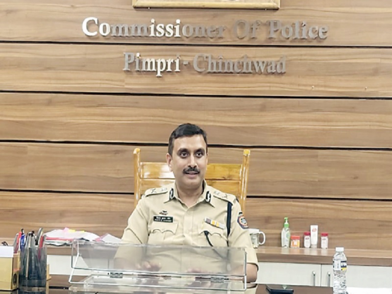 Vinoy Kumar Choubey at his desk beneath the Commissioner of Police, Pimpri-Chinchwad signage.