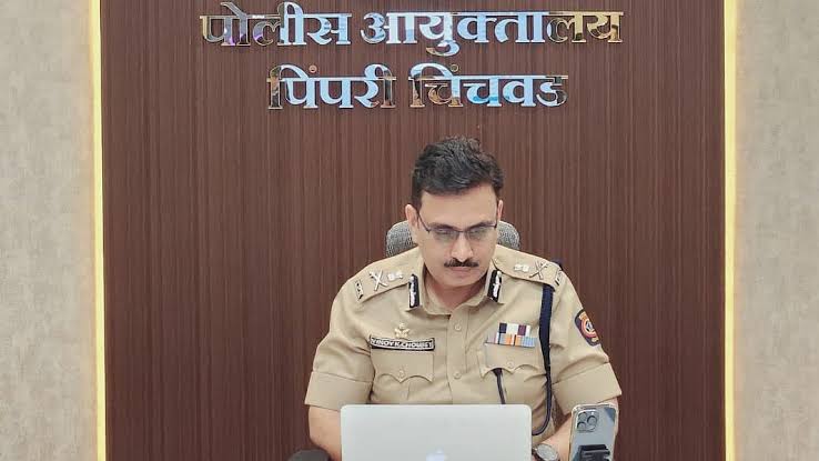 Vinoy Kumar Choubey working at the Pimpri-Chinchwad Police Commissionerate, the office signage in Marathi behind him.