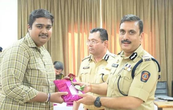 Vinoy Kumar Choubey presenting a felicitation to a citizen at an official ceremony, with a senior officer alongside.