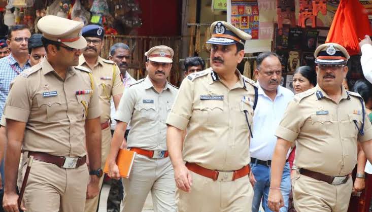 Vinoy Kumar Choubey walking through a busy market street on a field inspection with senior police officers.